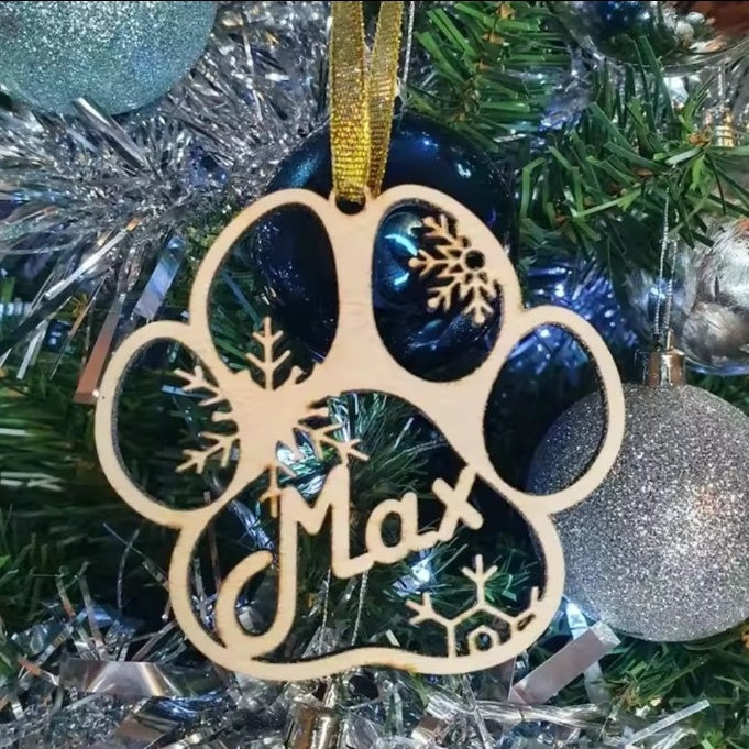 Wooden personalised Christmas dog paw ornament displayed on a Christmas tree